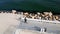 A man rides a longboard on a seaside promenade, seen from a drone