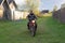 A man rides a motorcycle on a village road.