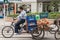 Man rides pedal tricycle with loading compartment, Shanghai, China