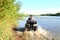 A man rides a White ATV with spray along the river