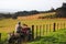 Man riding atv with dog alone fence rural area