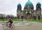 Man riding bicycle Berlin Cathedral at Lustgarden park Museum Island