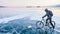 Man is riding bicycle on the ice. Ice of frozen Lake Baikal. Tee