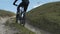 Man Riding Bicycle up Mountain Grass Hill