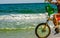 Man Riding a Bycicle on White Sand on Blur Ocean Water Background. Destin Beach, Florida