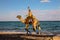 Man riding a camel on the beach