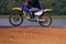 Man riding enduro motorcycle on dirt field