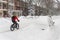 A man is riding a fat tire snow bike during snow storm