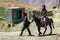 A man riding a horse in a remote Himalayan village