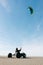 Man riding kite-buggy on the beach.