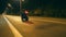 Man riding on modern sport motorbike at night street of town. Motorcyclist racing his motorcycle on evening city. Guy