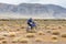 Man riding a motor cross bike in the steppes of Mongolia, on the hills of Mongolia