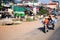 Man riding motorbike carrying large mattress and man on trailer