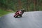 Man riding motorcycle in asphalt road. Motorcyclist in black suit at red sport motorcycle
