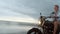 Man in riding motorcycle on beach. vintage motorbike on beach sunset on Bali. Young hipster male enjoying freedom and