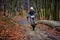 Man riding a motorcycle fast in autumn forest. Blurred background is in motion