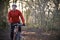 Man Riding Mountain Bike Through Woodlands