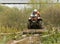 Man riding a quad meets an obstacle in the form of a tree trunk.