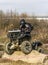 Man riding a quad meets an obstacle in the form of a tree trunk.