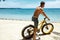 Man Riding Sand Bicycle On Beach. Summer Sport Activity