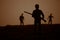 Man with riffle against zombie attack. Zombie apocalypse. Scary view of blurred zombies at cemetery and spooky cloudy sky with fog