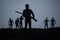 Man with riffle against zombie attack. Zombie apocalypse. Scary view of blurred zombies at cemetery and spooky cloudy sky with fog