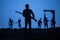 Man with riffle against zombie attack. Zombie apocalypse. Scary view of blurred zombies at cemetery and spooky cloudy sky with fog