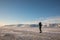 Man with a rifle and binoculars looks out on the horizon in arctic landscape at Svalbard