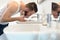 Man rinsing his toothbrush under running water