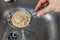 Man rinsing raw quinoa seeds