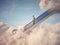 Man rises up on escalator into the clouds