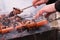 a man roasts meat on a fire. Close-up of hands and shish kebab.