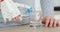 Man with robotic prosthetic hand is pouring water in glass from the bottle and drinking it in the kitchen.