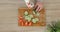 Man with robotic prosthetics hand with knife on it is trying to cut cucumber for slices on wooden board.