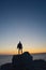 man on a rock alone facing the sea