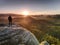 Man on rock with hands in trousers pocket  watch enjoy daybreak