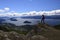 A man on a rock observes the landscape on San Carlos de Bariloche, view of the lake and the city of Bariloche