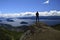 A man on a rock observes the landscape on San Carlos de Bariloche, view of the lake and the city of Bariloche