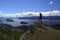 A man on a rock observes the landscape on San Carlos de Bariloche, view of the lake and the city of Bariloche