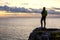 Man on a Rocky Ocean Coast during Sunset