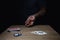 Man Rolling Set of Poker Dice on Wooden Table