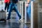 A man with a rolling suitcase passing through stainless steel ticket gates with motion blur