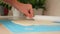 A man rolls yeast dough into pizza layer with a silicone rolling pin on mat. Cooking homemade pizza.