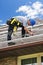 Man on roof installing rails for solar panels