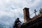 Man on the roof of an old house fixing the chimney with a trowel