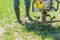 Man in rubber boots and blue jeans with a tractor motoblock  for plowing fields