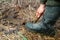 man in rubber boots digs a shovel pit in a swamp. Finding water