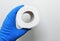 A man in rubber gloves holds a roll of toilet paper on a white background.Disinfection in public places, the fight against the vir