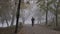 Man run in park in foggy autumn morning