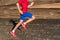 Man runner athlete running on trail run path in mountains. Legs and running shoes in motion on rocky terrain. Knee, hip, thigh,